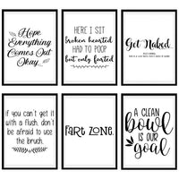 Six different printable bathroom signs and their sayings hanging in frames.
